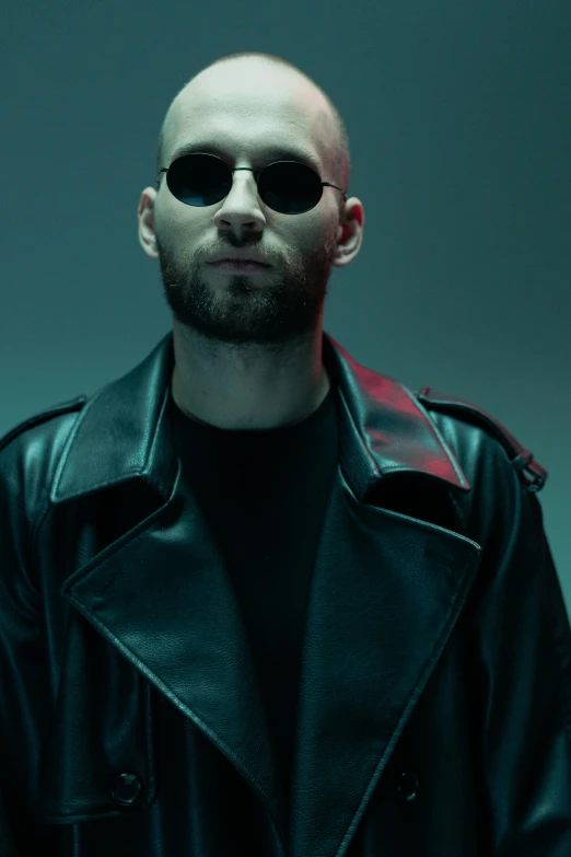 a man wearing a black leather jacket, sunglasses and a black tee shirt