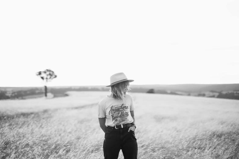 a man in a hat standing on a grass field