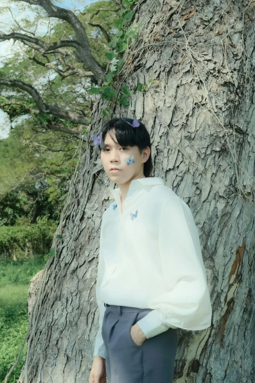 a woman with white makeup wearing grey pants and an off - white blouse