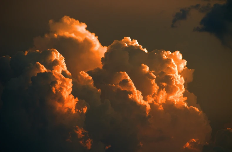 an airplane flying in the sky next to a large cloud