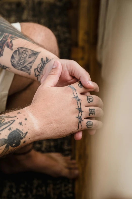 tattooed male holding onto the wrist of a woman