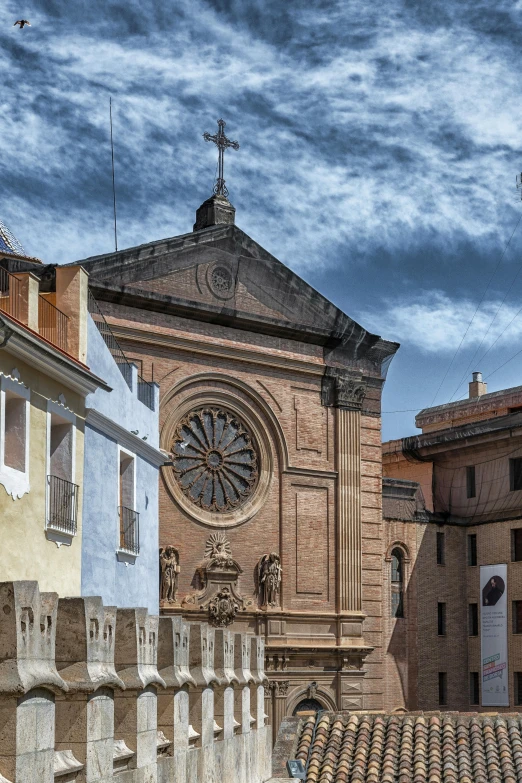 the front view of a tall church against cloudy skies