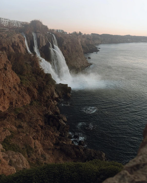 a large waterfall falling from a mountain with water coming out of it