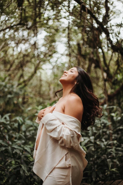 woman standing near some trees looking up in the sky