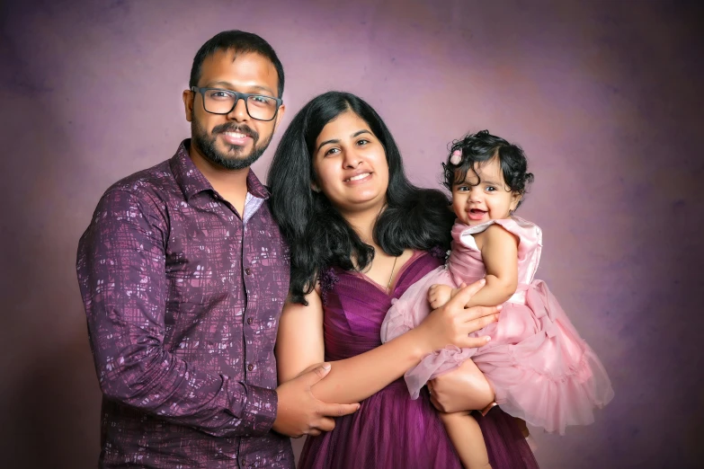 this is an image of a young man and woman posing with a toddler girl