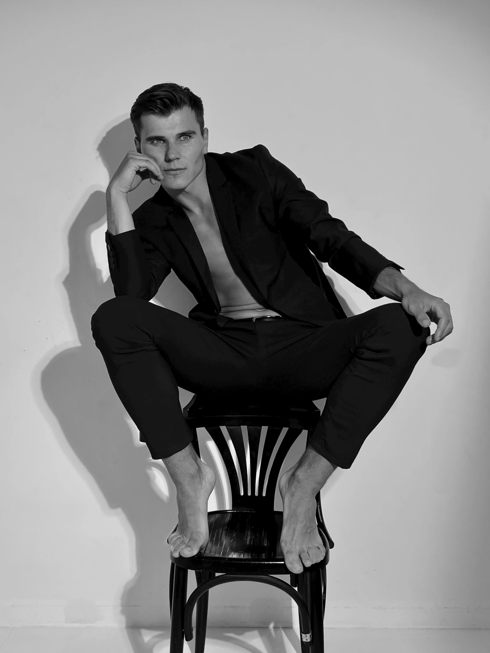 a man in a suit sitting on top of a chair