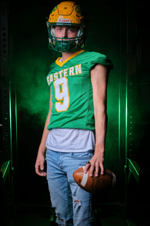 a football player with a green uniform and yellow helmet holding a football