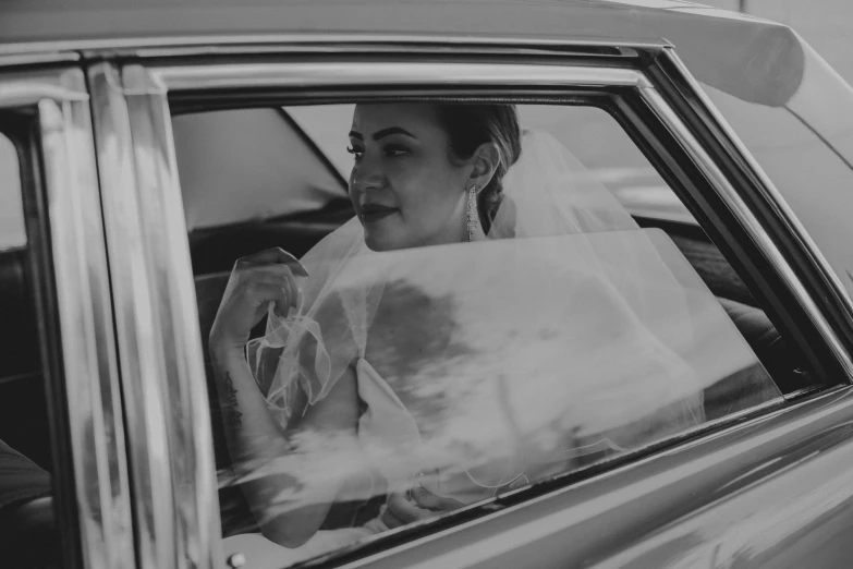 a black and white po of a bride inside of a car