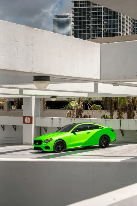 the green mercedes benz in front of some white buildings