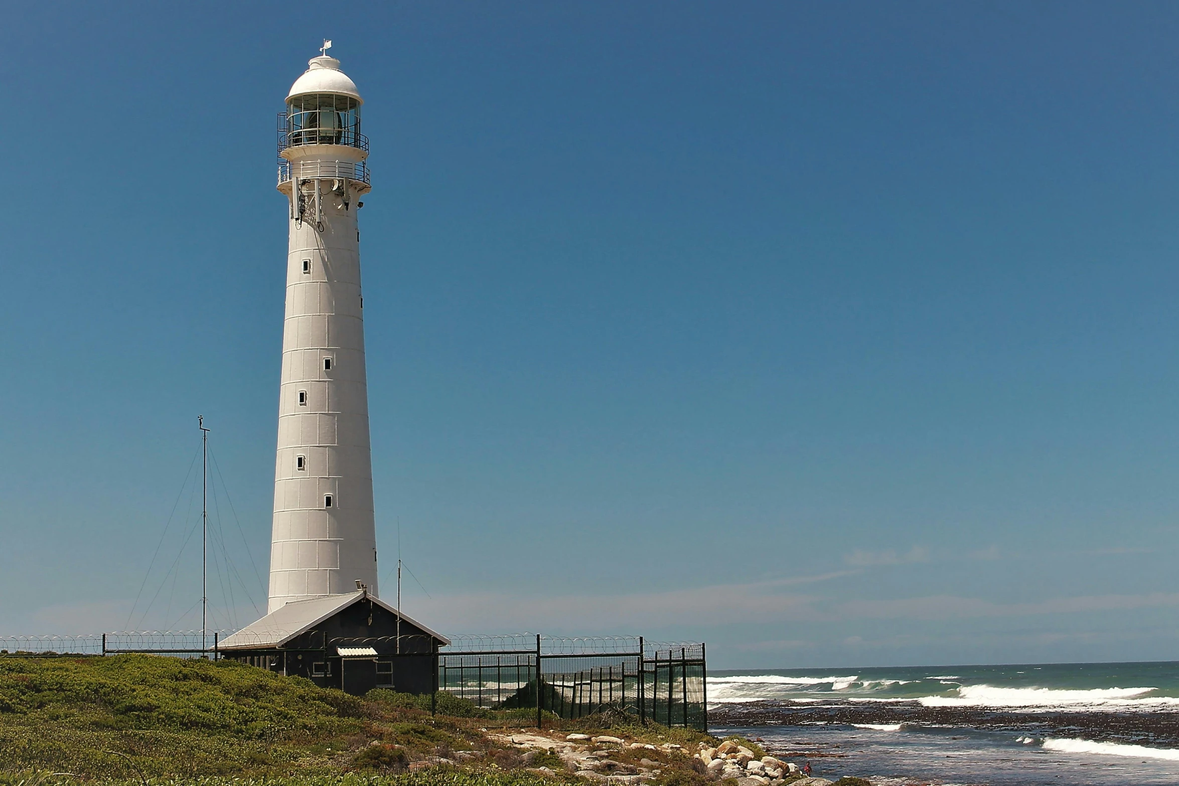 a light house on the shore by the ocean