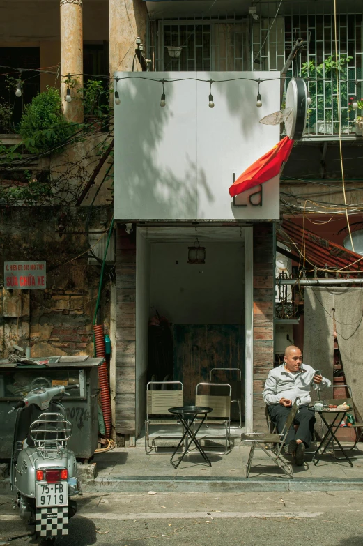 a person sitting outside in a chair on the side of a road