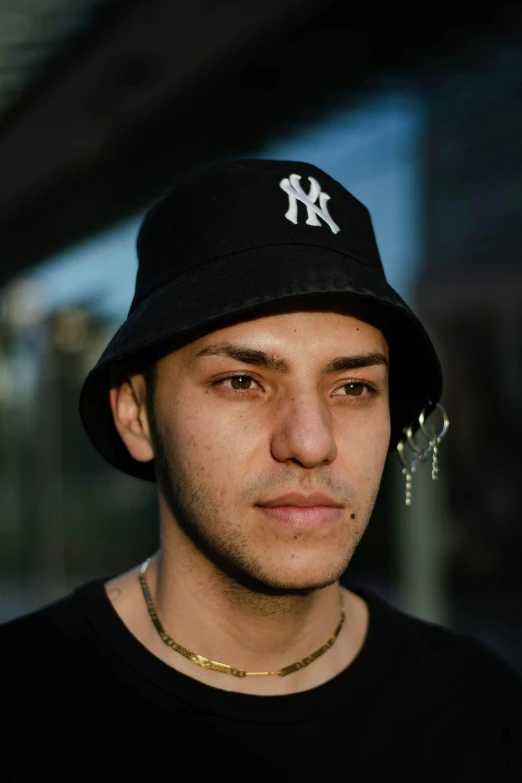 a young man poses for a po wearing a hat