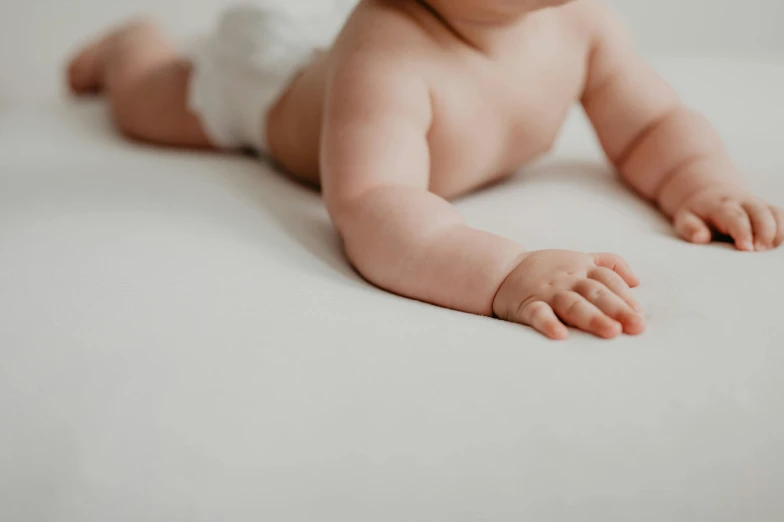 a baby in diapers is laying on the bed