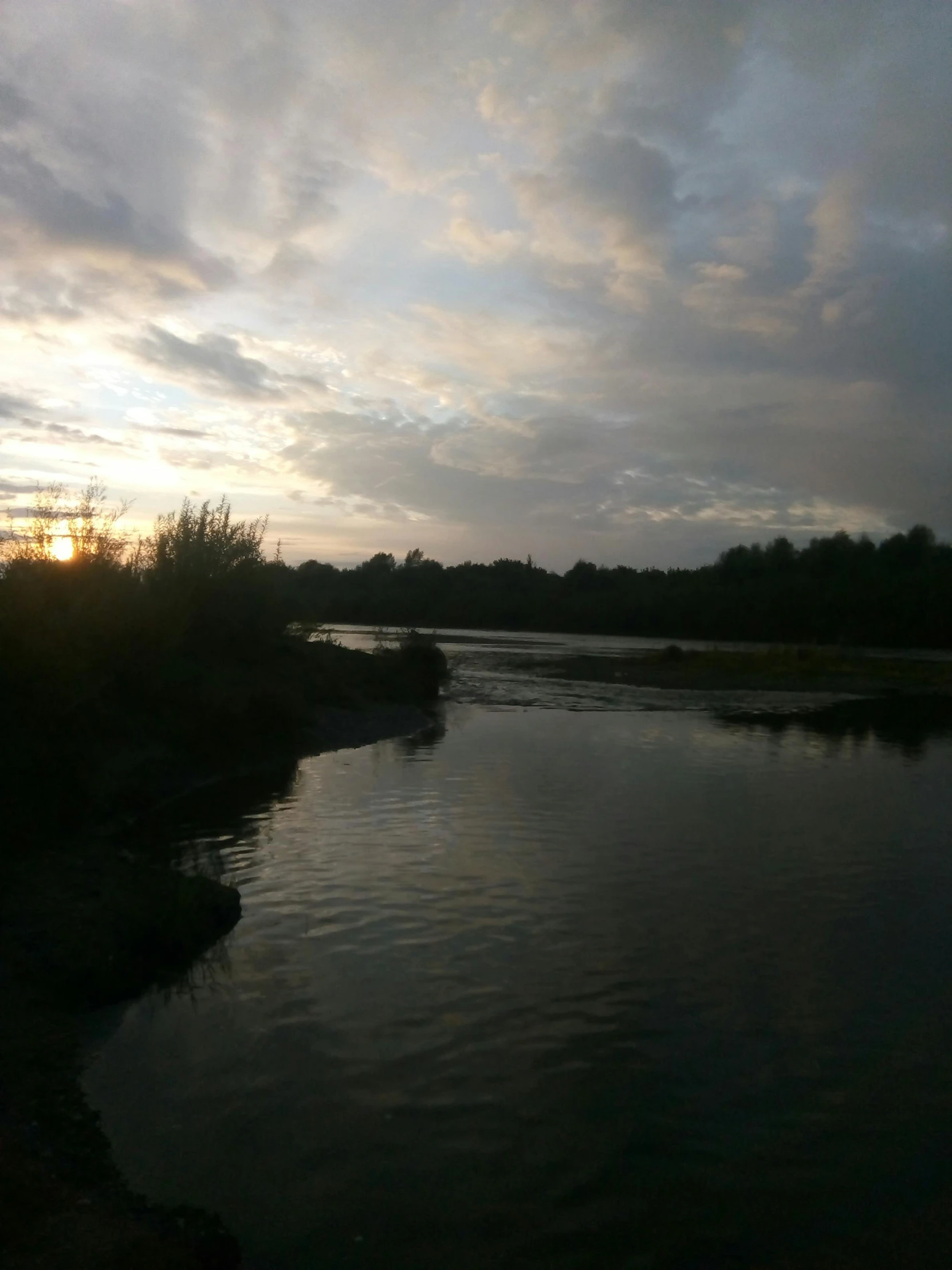 the water is quiet and it reflects the sky