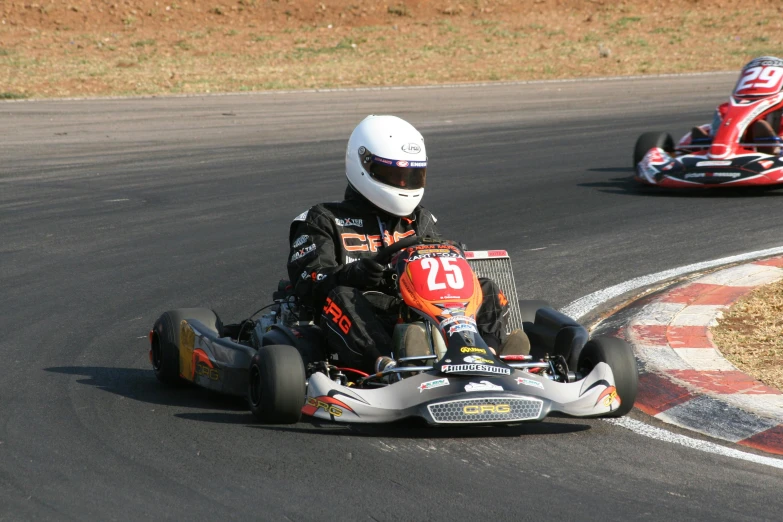 two people riding go kart vehicles in a race