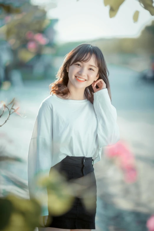 a beautiful young woman standing in front of flowers