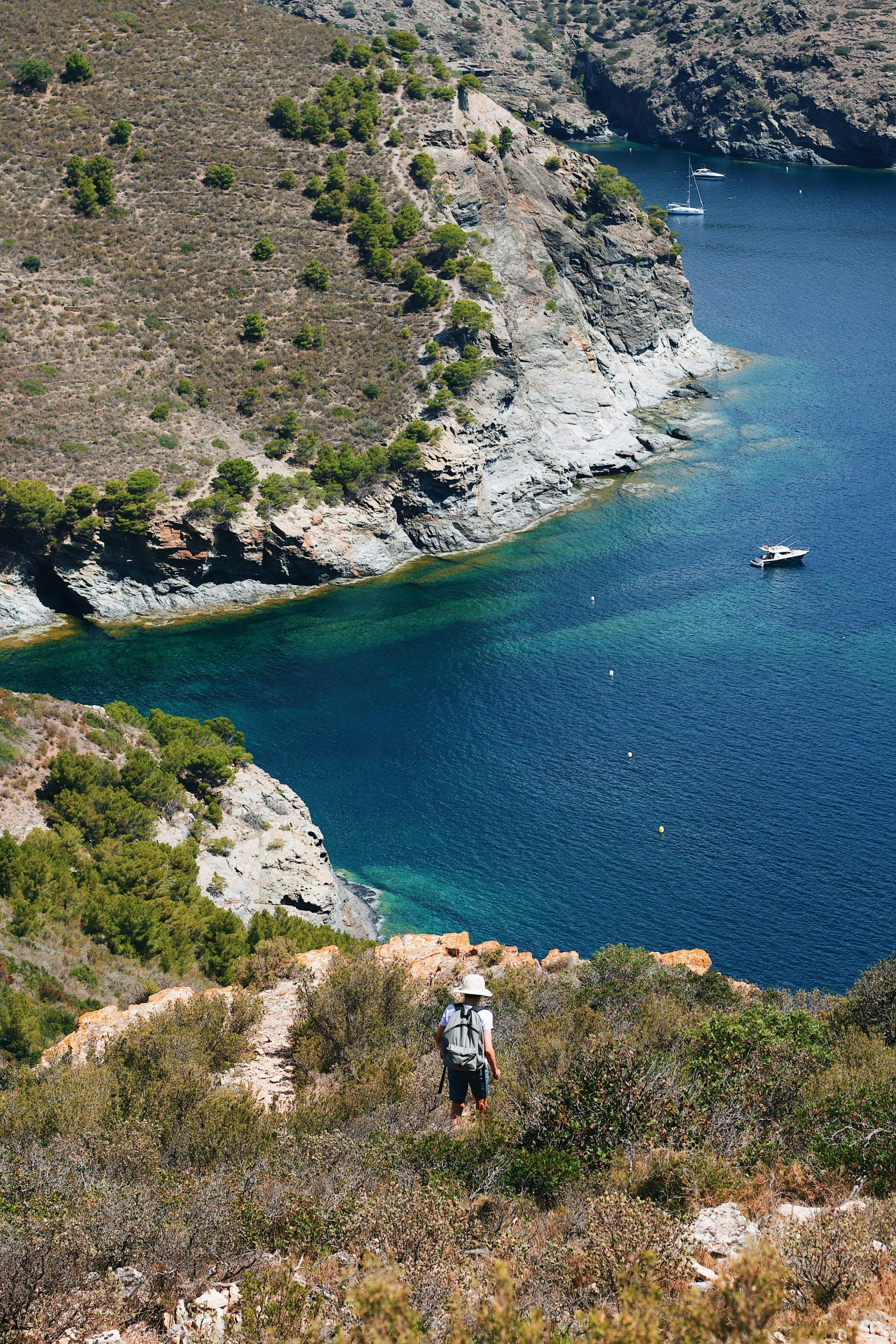 the man is standing on the ledge by the water