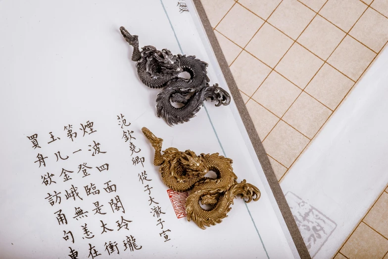 a metal dragon key sitting next to an envelope