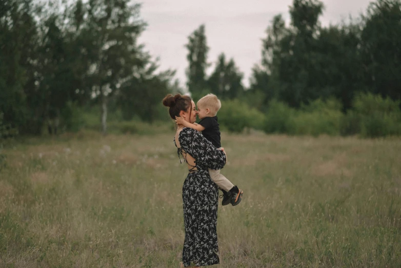 a woman is holding a child with her arms wrapped around him