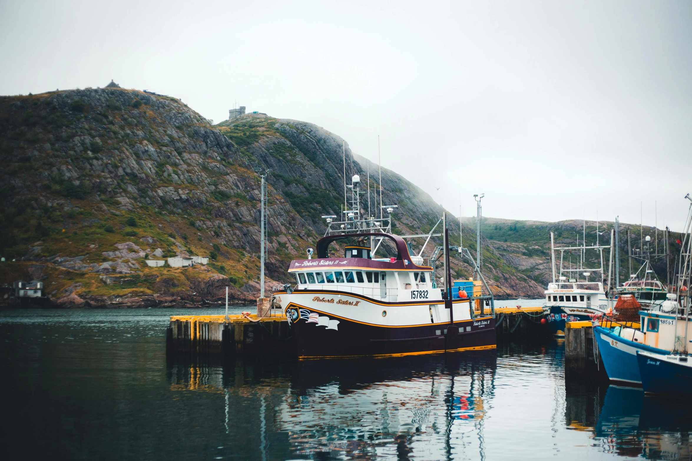 a group of boats at a dock on a river