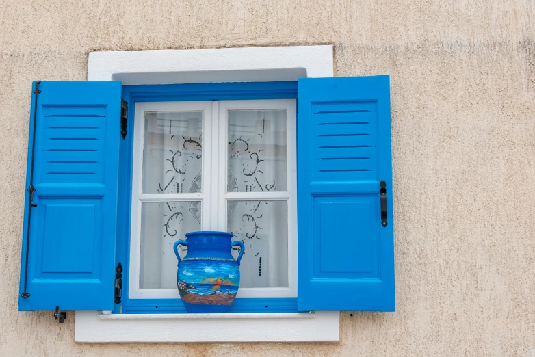 a vase is seen behind a blue window