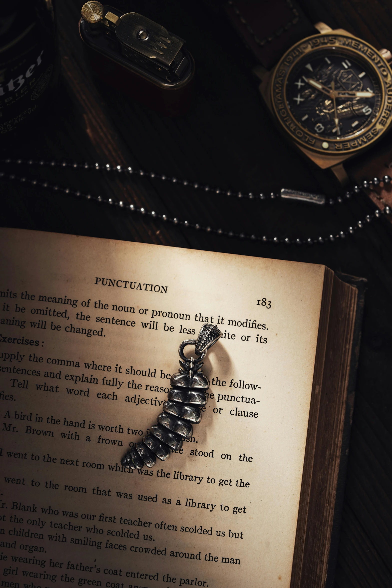 a book open to a page with a watch on the table