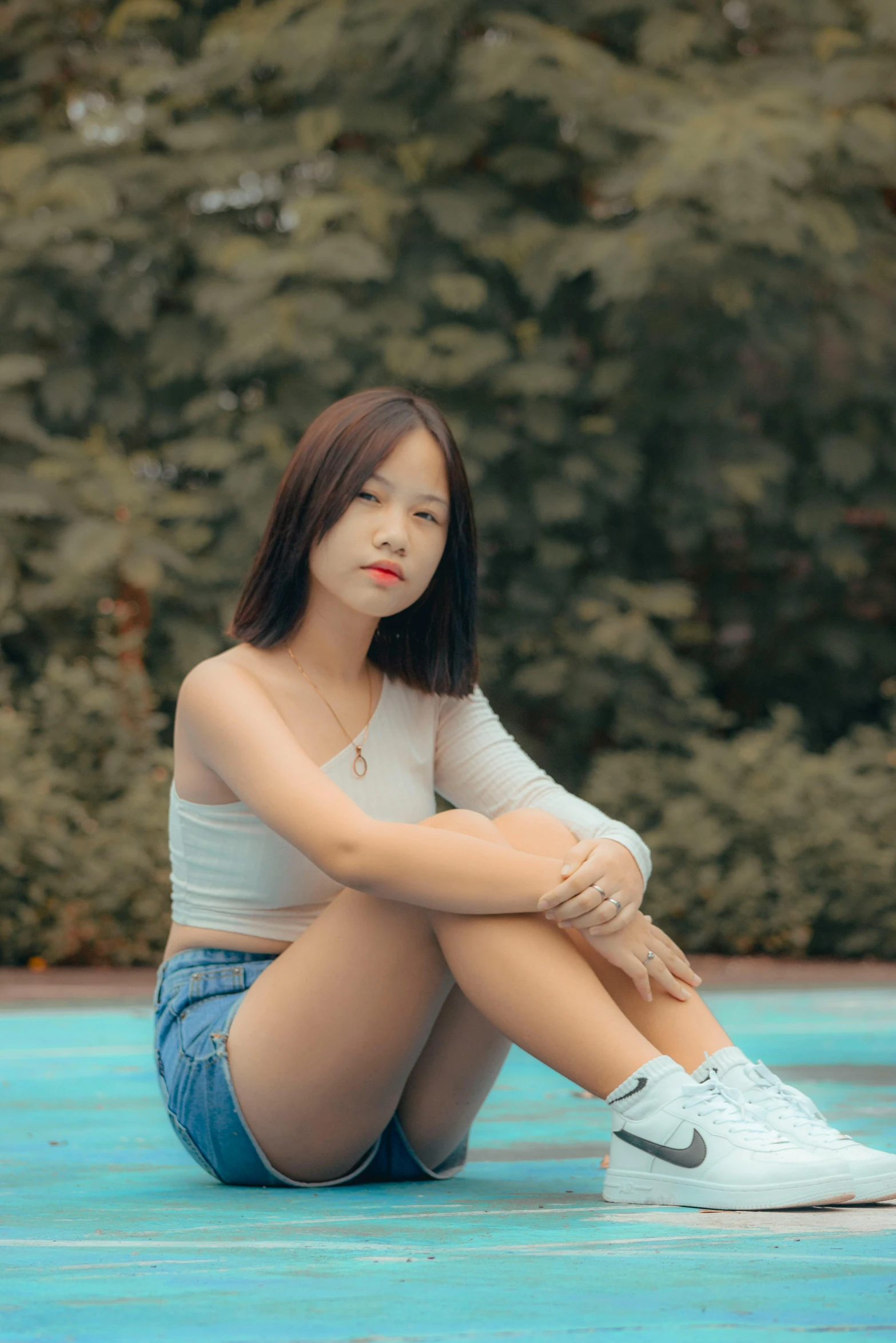 a woman with her legs crossed sits on the ground