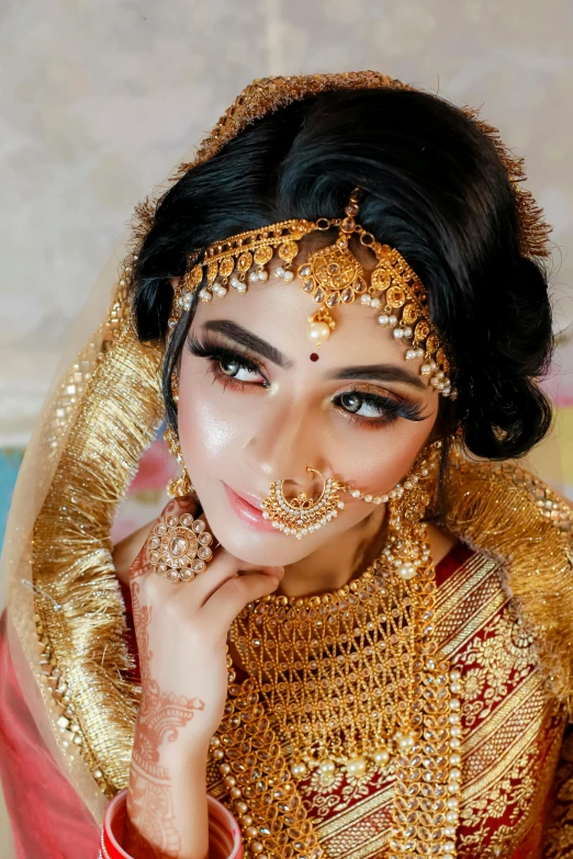 a woman is dressed in gold for her wedding