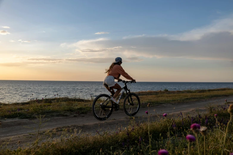 the woman is riding her bike down the hill to see the water