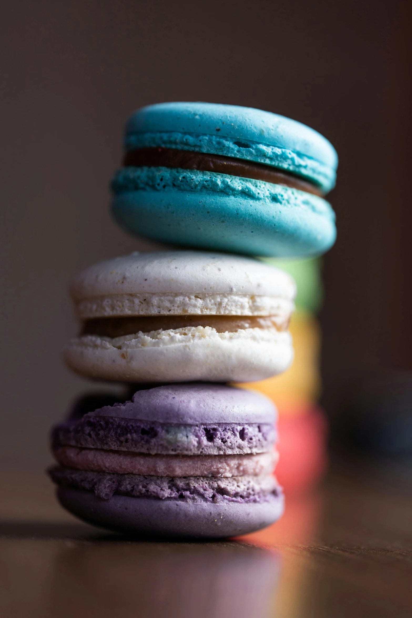 four macarons stacked in the same pile, one being blue, one green