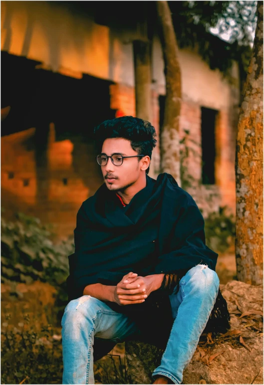 a man sitting on a rock posing for a po