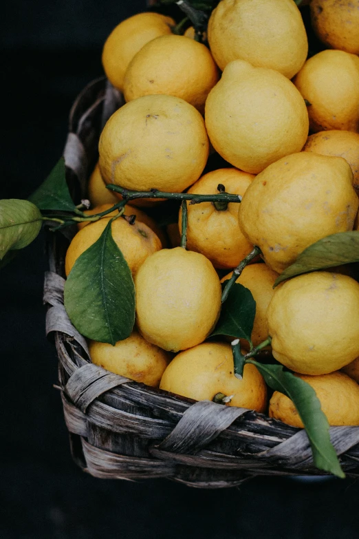a bunch of lemons sit in a basket