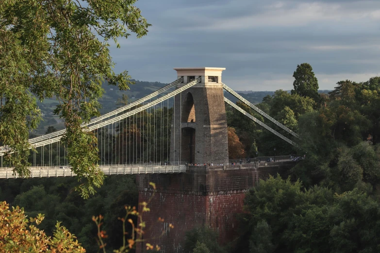 an old bridge crosses over a river below the cloudy sky