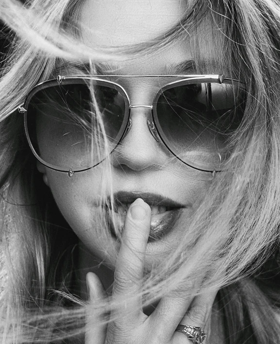 a woman with blonde hair wearing sunglasses in a black and white po