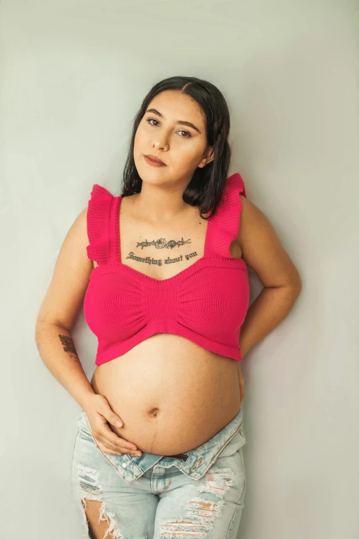 a pregnant woman with black hair poses for a picture