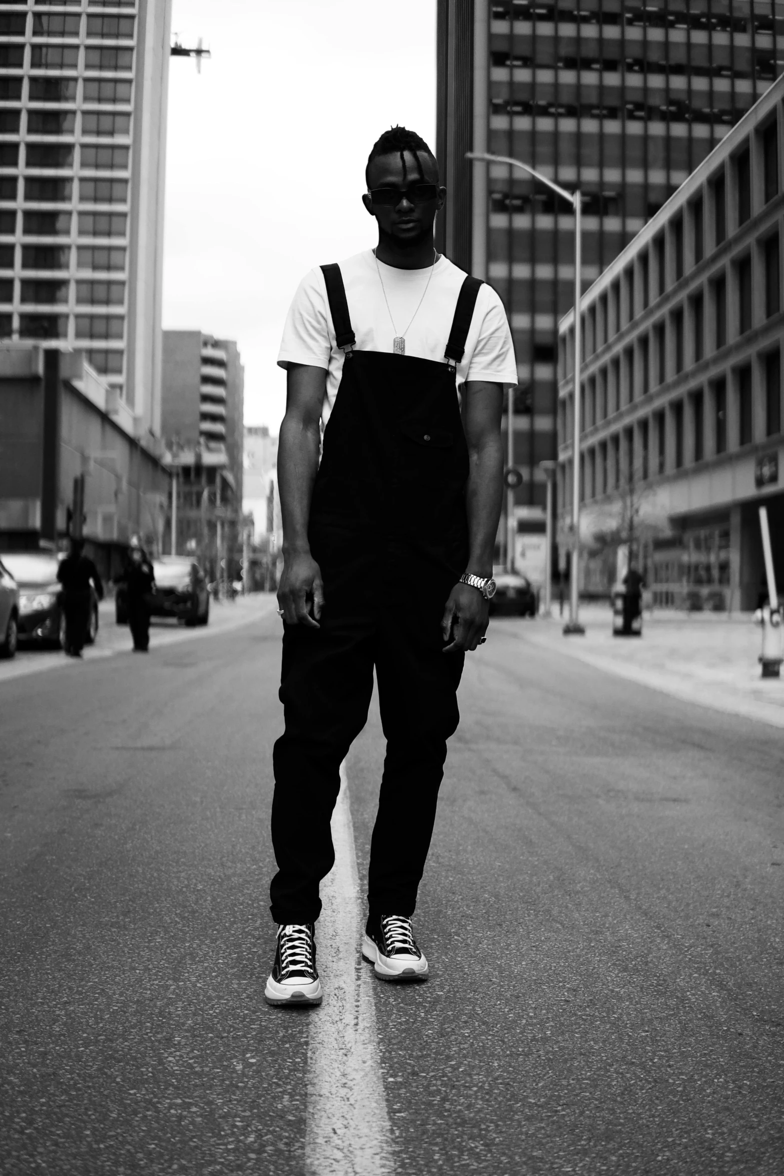 a young man is standing on the street in front of tall buildings