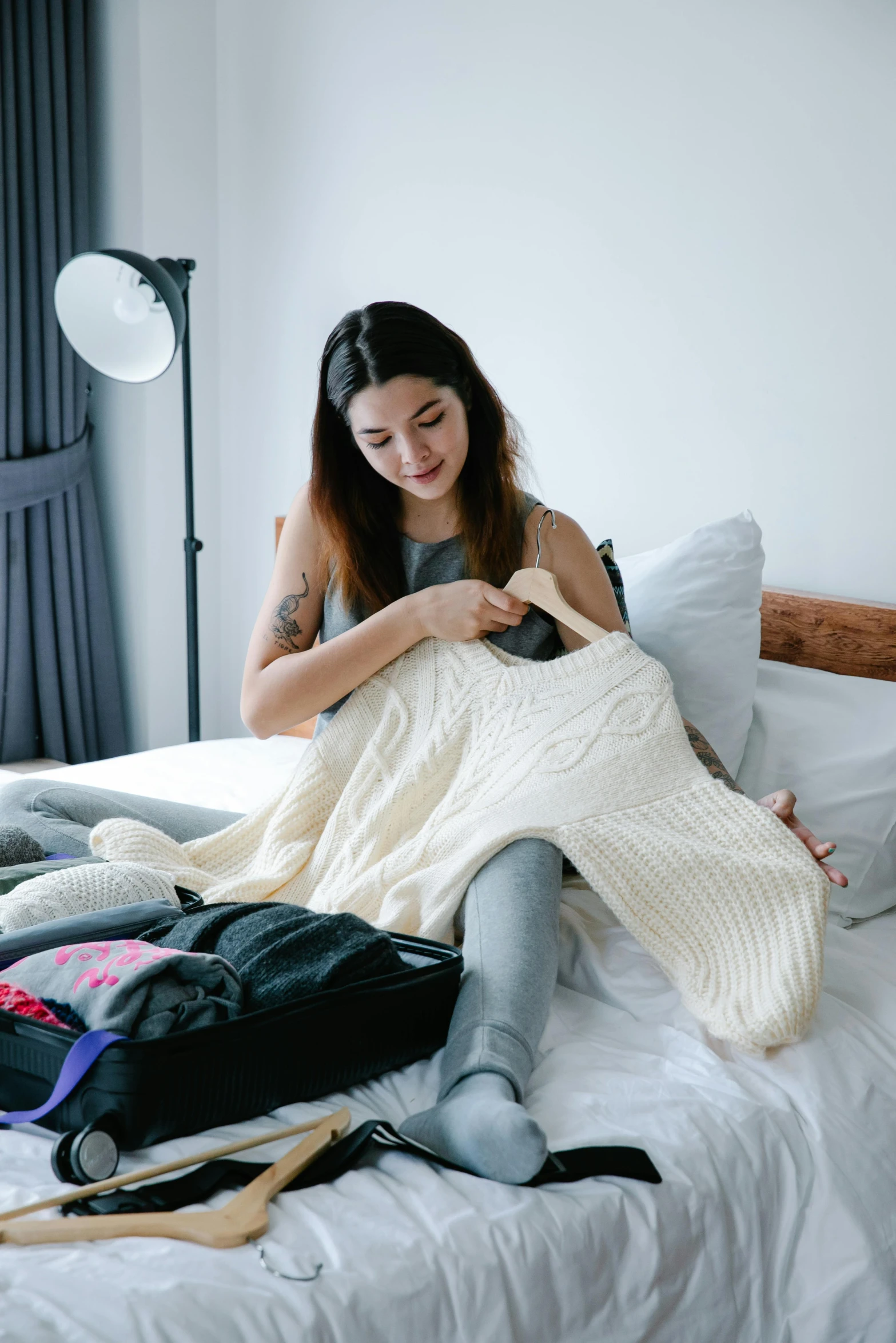 a woman laying on a bed holding her blanket