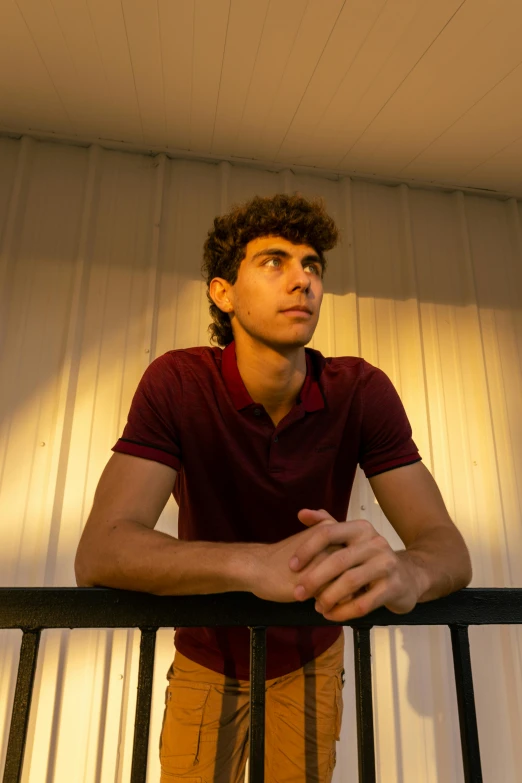 a young man standing on a balcony next to his railing