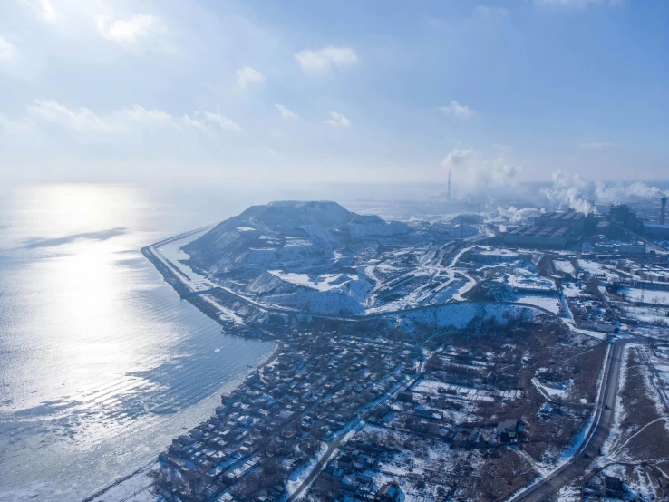 an aerial view of snow covered towns and a body of water