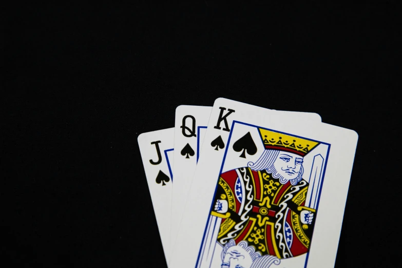 four royal spades holding each other on a dark background