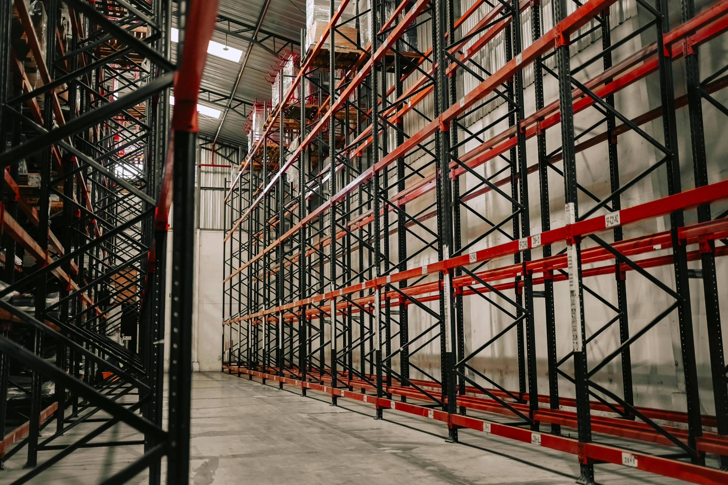 the inside of a warehouse with orange and red shelving