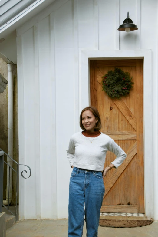 a woman posing in front of an entrance to a house