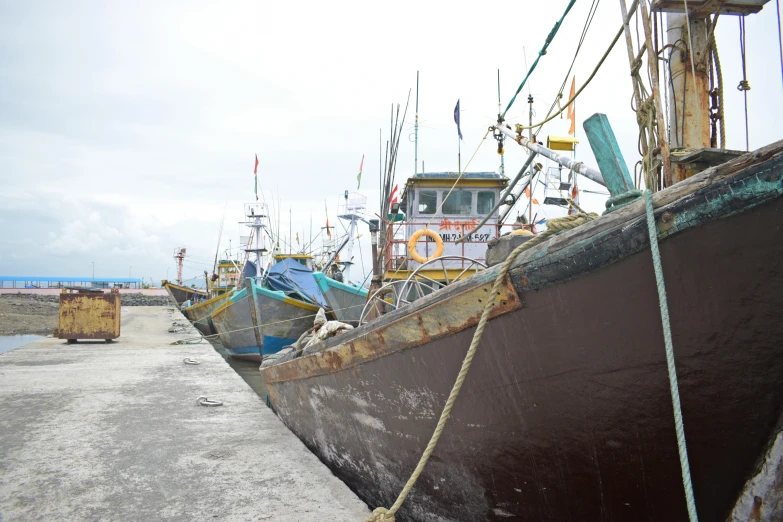 some old boats on the dock with some wires hanging off them