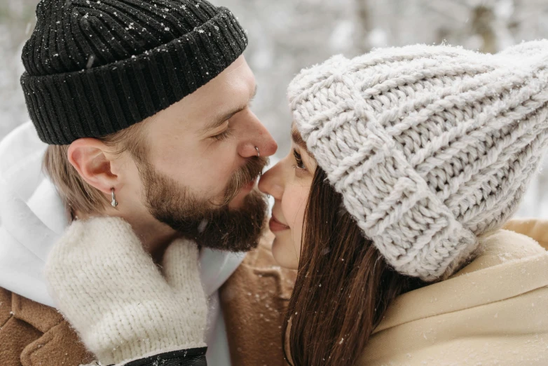 a man and woman in the winter kissing each other