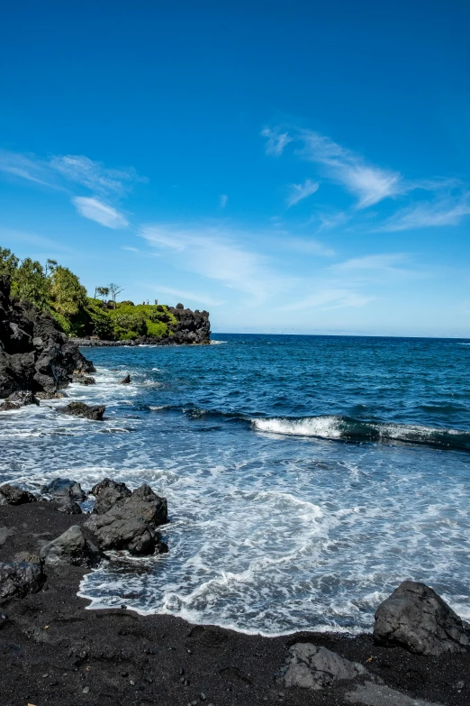 blue water is rolling in and out from a cliff