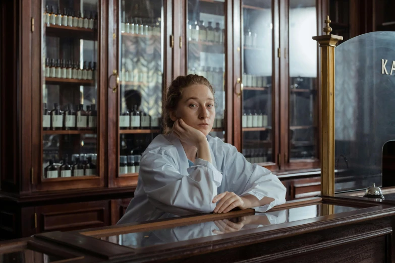 a woman in a chef's coat sitting at a counter