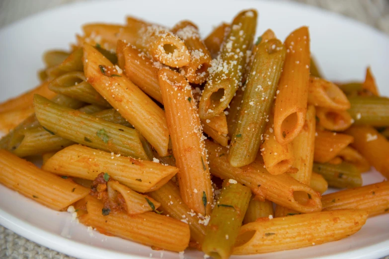 a plate of penni, including peppers and parmesan cheese