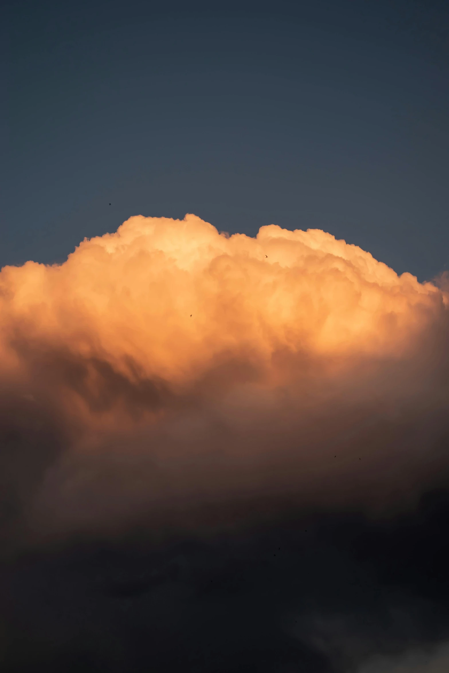 the cloud is bright with dark clouds in the distance