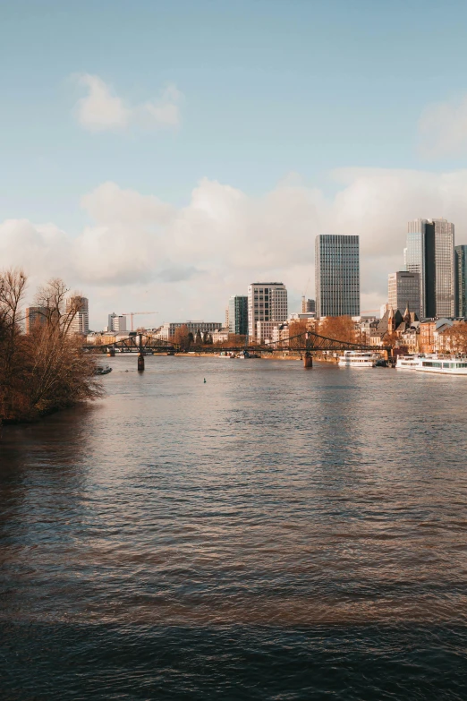 a city skyline near water with boats on the water