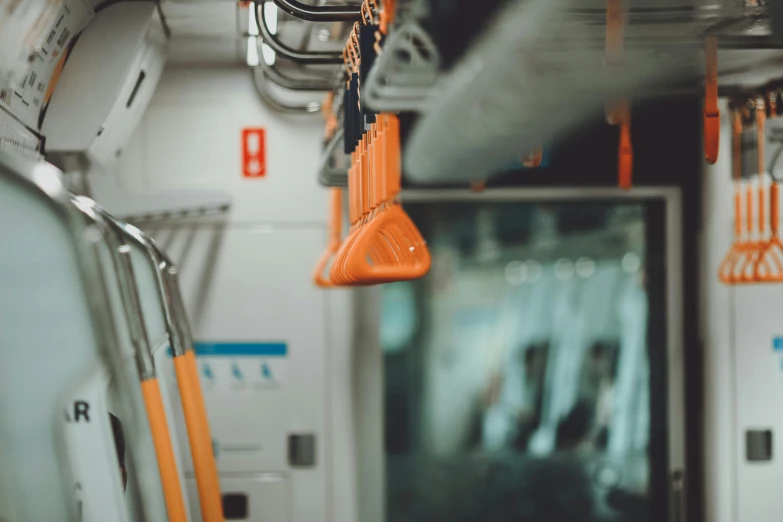 rows of orange hanging from hooks on a train